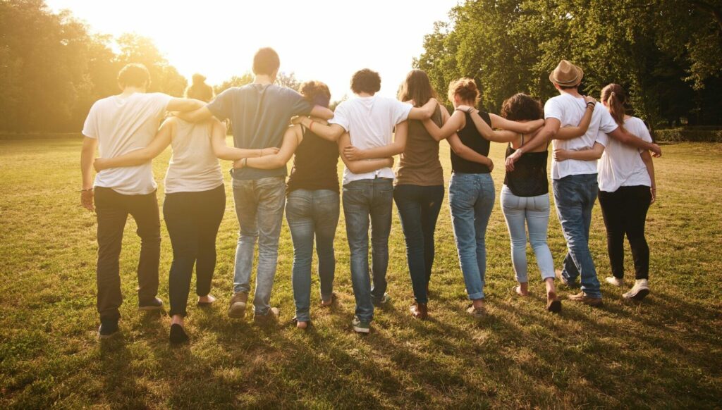 Menschen halten sich in einer Reihe in den Armen. Bild der Gemeinschaft