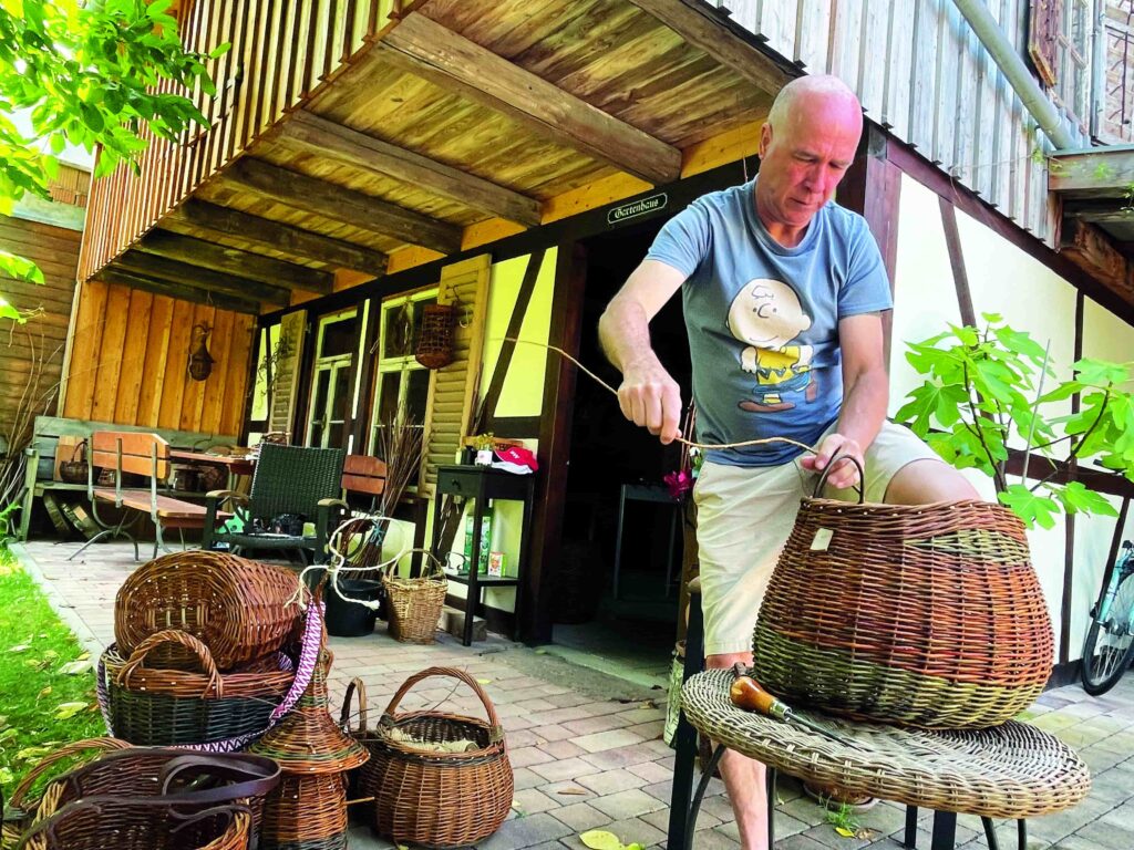 Mann flechtet gerade einen Korb.
